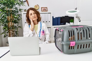 Canvas Print - Middle age veterinarian woman working at pet clinic touching mouth with hand with painful expression because of toothache or dental illness on teeth. dentist