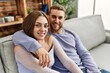 © Krakenimages.com - Young caucasian couple sitting on the sofa hugging at home.