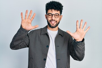 Sticker - Young arab man with beard wearing glasses showing and pointing up with fingers number ten while smiling confident and happy.