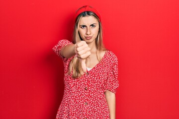 Poster - Beautiful hispanic woman wearing summer dress looking unhappy and angry showing rejection and negative with thumbs down gesture. bad expression.