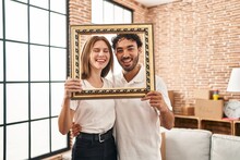 Young Two People Holding Empty Frame Together Smiling And Laughing Hard Out Loud Because Funny Crazy Joke.