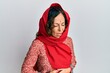 © Krakenimages.com - Middle age hispanic woman wearing tradition sherwani saree clothes with hand on stomach because nausea, painful disease feeling unwell. ache concept.