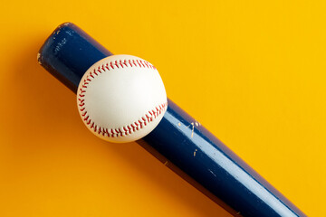 Wall Mural - Baseball ball on a wooden baseball bat on yellow background