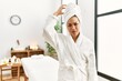 © Krakenimages.com - Young brunette woman wearing towel and bathrobe standing at beauty center confuse and wonder about question. uncertain with doubt, thinking with hand on head. pensive concept.