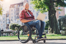 Freelancer With A Physical Disability In A Wheelchair Working At The Park