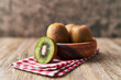  Bowl of bunch of kiwis and slice on a wooden table