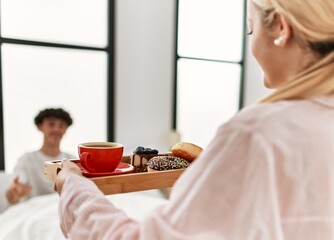 Poster - Woman surprising her boyfriend with breakfast on the bed at home.