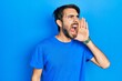 © Krakenimages.com - Young hispanic man wearing casual clothes shouting and screaming loud to side with hand on mouth. communication concept.