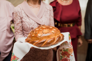 one of the Russian traditions at the wedding is to meet the newlyweds with a loaf of bread