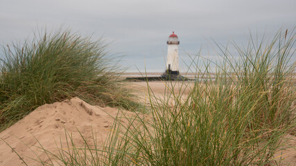 Wall Mural - beautiful sunrise landscape image of talacre beach lighthouse at surnise with dramatic sky and cloud