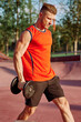© VICHIZH - male athlete with dumbbells in hands training in the park