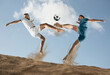 Two men footballers are desperately playing beach soccer on sand on a sunny day