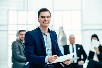 Wall Mural - portrait of a confident young businessman on an office background