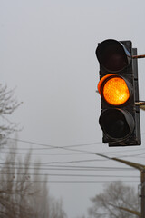 A traffic light showing a yellow light and requiring attention. Regulation of street traffic, using traffic light signals.