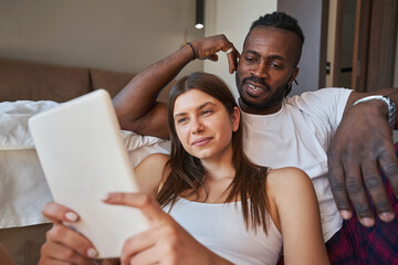 Wall Mural - Concentrated female and man watching something on gadget