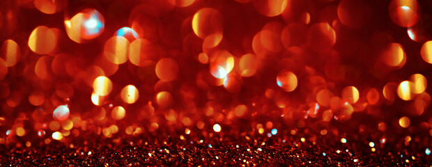 Poster - Christmas red with gold glowing background. Golden Holiday Abstract Glitter Defocused Backdrop With Blinking Stars and garlands, sparks. New year holiday glow background, bokeh. Wide screen