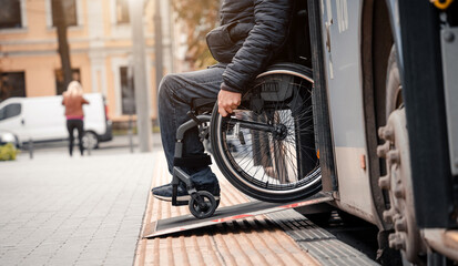 Person with a physical disability exits public transport with an accessible ramp.