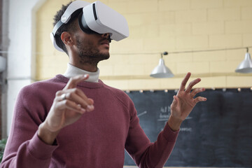 Poster - Young contemporary businessman in virtual reality headset preparing or looking through online presentation