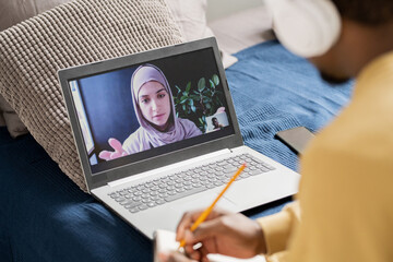 Aufkleber - Young confident teacher on laptop screen looking at African student while explaining him subject of online lesson