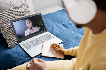 Aufkleber - Young confident teacher in hijab explaining point of lesson to student with pencil and notepad during online lesson