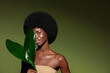 © Beauty Agent Studio - Natural organic cosmetics concept.  Beauty portrait of young beautiful african american woman with posing with exotic leaves, curly afro hair against green exotixc plants background.