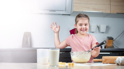 the girl in the kitchen prepares cookies and waves her hand. making cookies