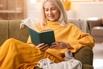 Sticker - Beautiful mature woman reading book at home on autumn day