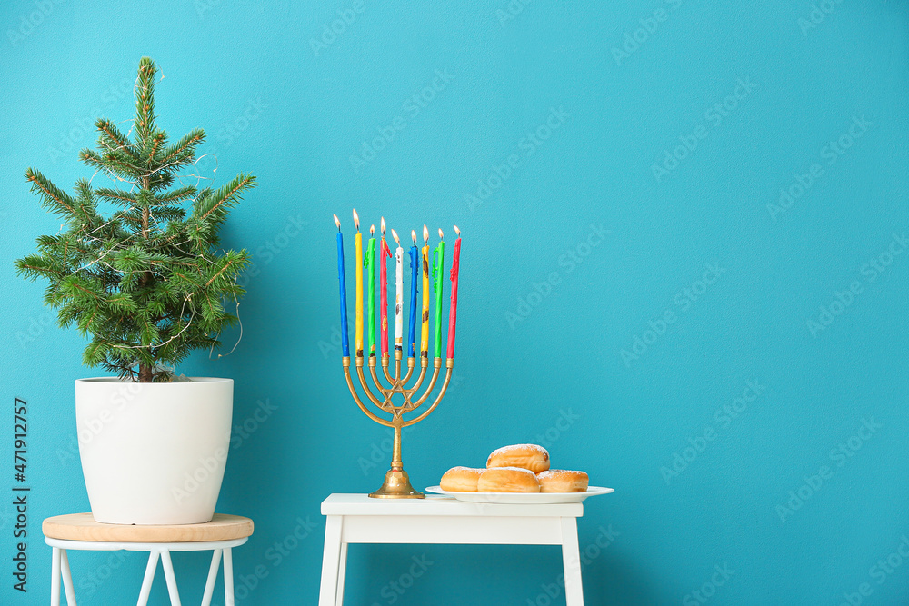 Menorah and donuts for Hanukkah celebration with Christmas tree in room