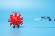 A Picture Of 3D Printed Coronavirus With Omicron Variant Word, Vaccine And Booster Shot Word. Booster Shot Helps To Fight New Variant.