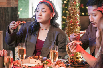 Party of beautiful asian friend female celebrating. women eating pizza on table with snack and drink. happiness friends christmas eve celebration dinner party food and champagne.