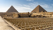 The Great Pyramids of Giza and the Sphinx against the blue sky.  In the foreground are rows of chairs for the audience. Egypt