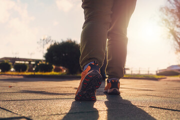 A overweight person in sports clothes, standing ready to run. Legs close-up. Bottom view. The concept of sports and weight loss