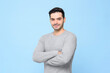 © Atstock Productions - Waist up portrait of smiling friendly handsome man in plain gray t-shirt with arms crossed isolated in light blue studio bakground