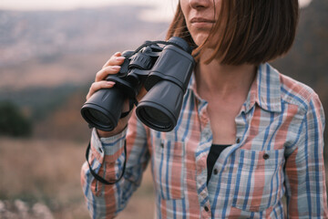 Wall Mural - Portrait of an unrecognizable young woman explorer with binoculars in her hands.