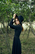 © VICHIZH - woman in black suit Witch in a fantasy forest