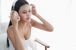 © u photostock - Asian woman sitting on the chair in morning with headphone and smart phone