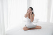 © u photostock - Asia woman sitting on the bed in morning with headphone and laptop
