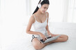 © u photostock - Asia woman sitting on the bed in morning with headphone and laptop