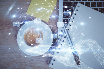 Poster - Envelop hologram drawing over computer on the desktop background. Top view. Double exposure. Technology concept.