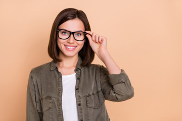 Sticker - Photo of positive lady hold specs look camera eye examination concept wear khaki shirt isolated beige color background