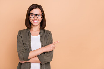 Wall Mural - Photo of freelancer promoter lady direct finger empty space wear specs khaki shirt isolated beige color background