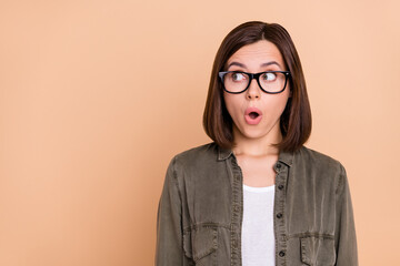 Canvas Print - Photo of crazy lady look empty space unbelievable news wear specs khaki shirt isolated beige color background