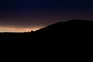 Wall Mural - Beautiful view of starry sky over mountains at night