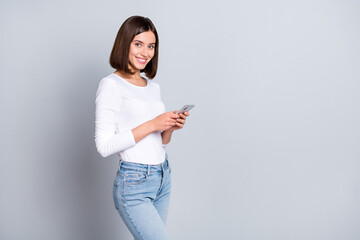 Wall Mural - photo of cool bob hairstyle young lady hold telephone wear pullover jeans isolated on grey color bac