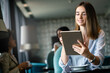 © NDABCREATIVITY - Attractive businesswoman using a digital tablet while sitting in cafe