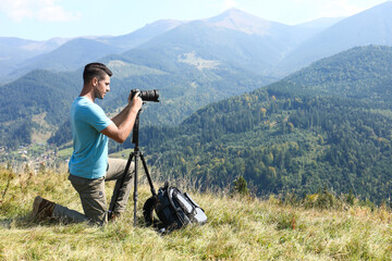 Canvas Print - Photographer with backpack, camera and tripod surrounded by breathtakingly beautiful nature