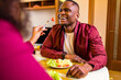© yurakrasil - Authentic people african american couple in love drinking wine from glasses and eating italian pasta in living room 14 february valentines day