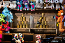 Throwing Booth At The Christmas Market With Cans, Ball And Colorful Plush Toys As Prizes, Selected Focus, Motion Blur