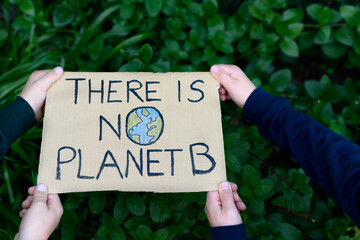 poster held by the hands of two children that reads: there is no planet b. concept of environmental 