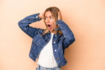 Wall Mural - Young caucasian woman isolated on beige background screaming, very excited, passionate, satisfied with something.